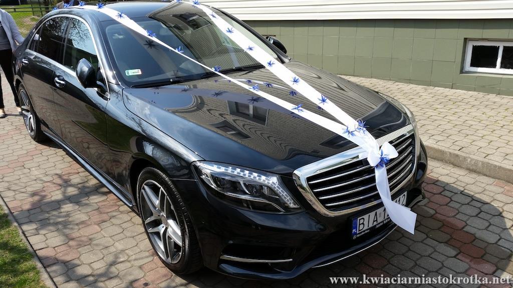 Samochód ślubny z kompozycją kwiatową na masce