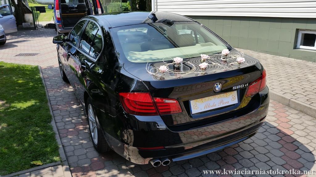 Samochód ślubny z dekoracją z delikatnych kwiatów